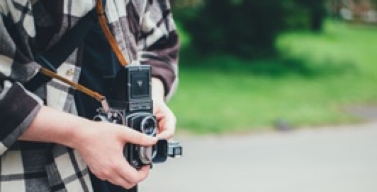  a photo of a person holding an old professional camera to represent design